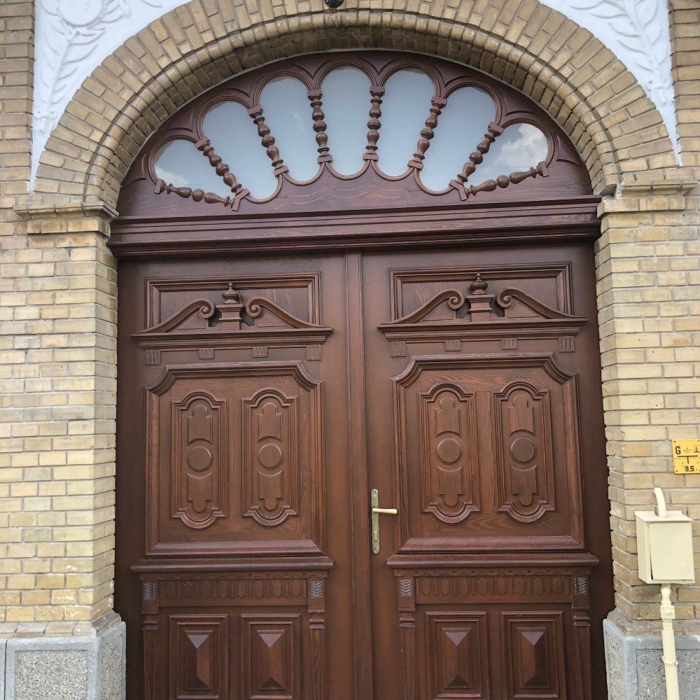 Egy fa nyílászáróval díszített ajtó, épület bejárat.